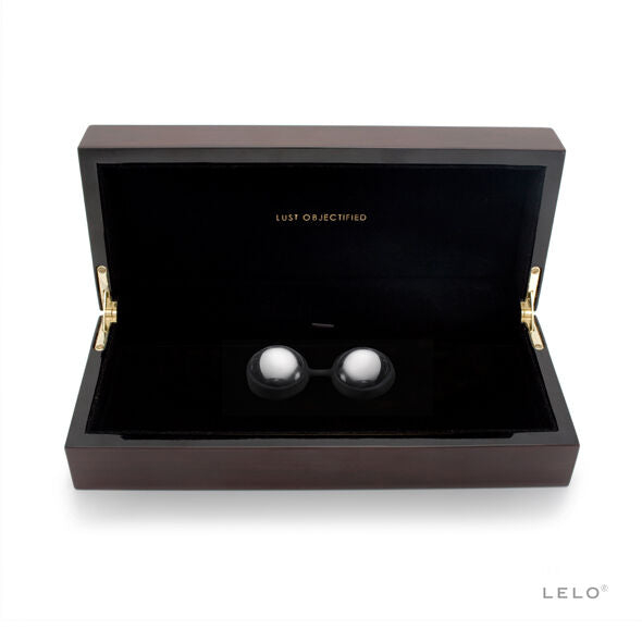 Coffret noir ouvert avec intérieur sombre contenant deux boules argentées