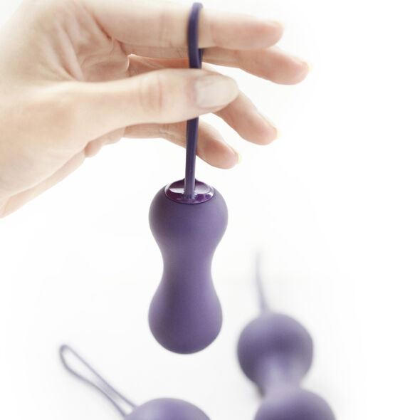 Main tenant une boule de Geisha violette en silicone avec tige fine et sphère lestée
